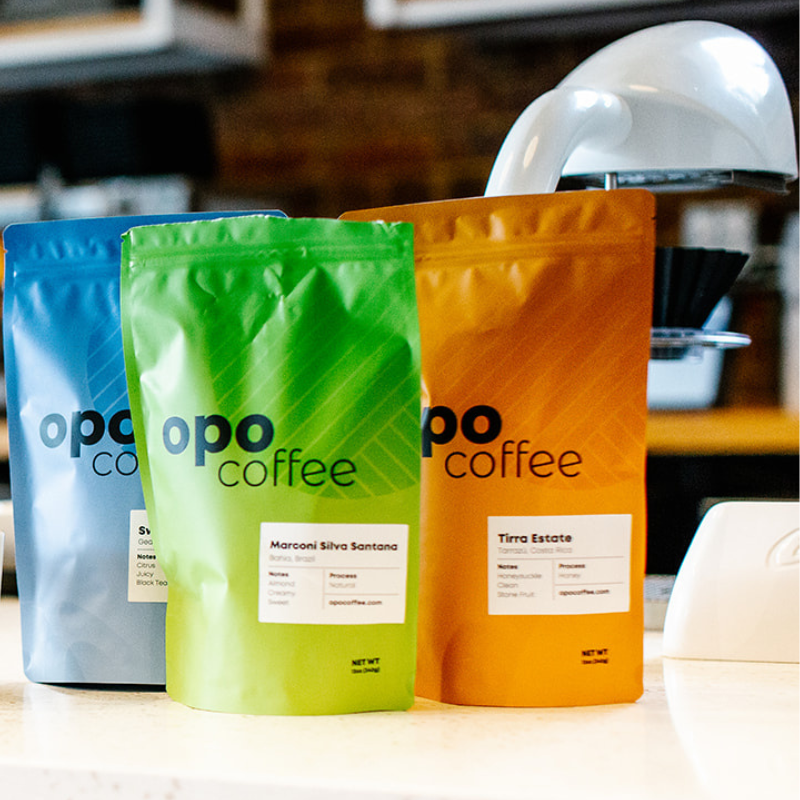 blue, green and orange coffee bags on white counter