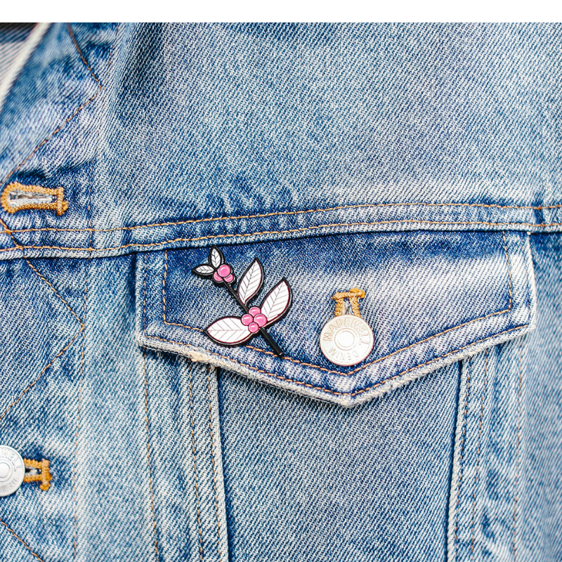 Pink and white coffee branch pin on denim jacket